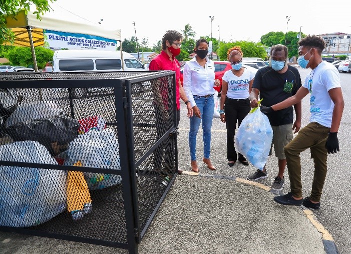 Photograph 1: Partners in the Plastic Action Pilot look on as shopper Patrick Morgan deposits a bag of plastic bottles during the initiative launch 