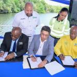 Signing underway. Chief Executive Officer, NEPA Leonard Francis (bottom left) signing the agreement along with Mr. Jorge Martinez; Managing Director of Carib Cement and Country Manager of Cemex Jamaica and the Bahamas (centre) and Mr. Anthony McKenize, Director, NEPA (right). Mr. Craig Neil, Legal Counsel/Company Secretary and Shannen Suckra Baker; Sustainability Leader, TCL Group - Jamaica, Barbados & Trinidad, CCL look on.  Credit: Jamaica Information Service